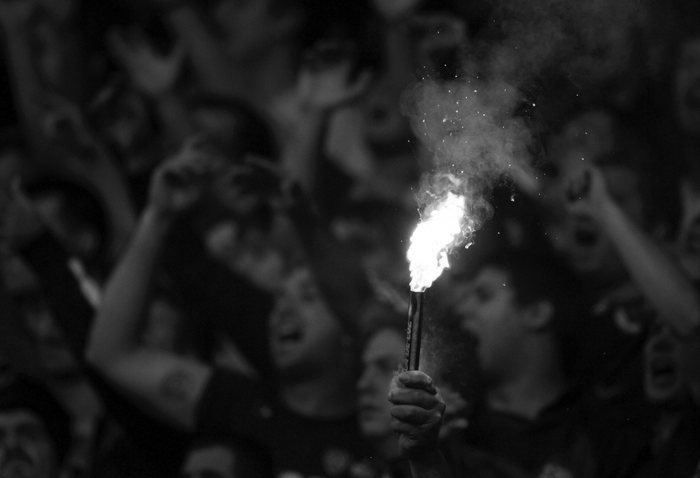 A Boca Juniors' fan holds a flare during their Argentine First Division soccer match against River Plate in Buenos Aires
